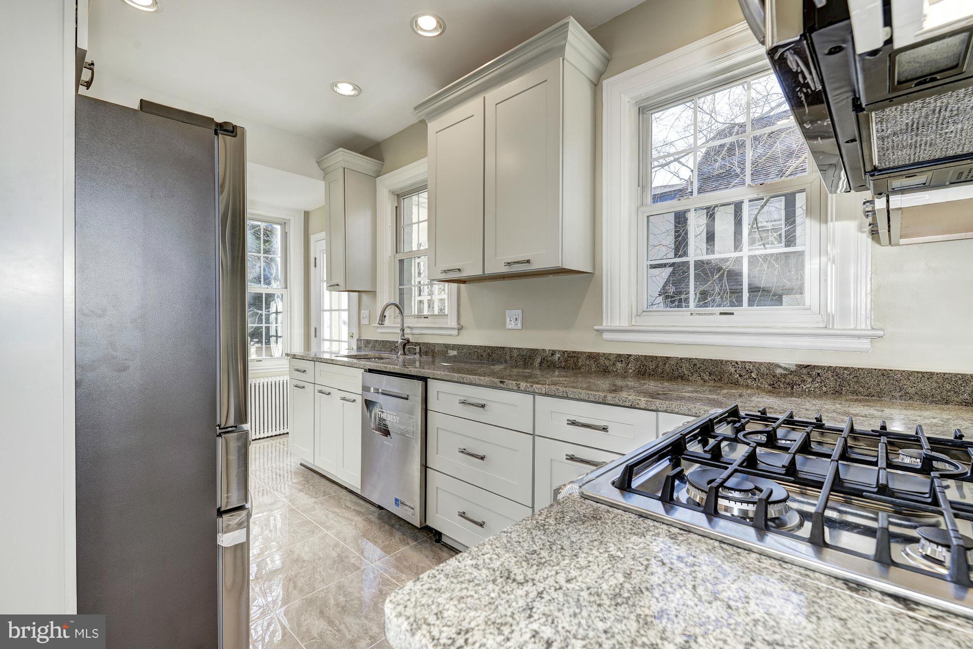 4910 Hillbrook Lane Northwest Washington, DC 20016 - Photo 10 of 30 a kitchen with stainless steel appliances granite countertop a sink stove and cabinets