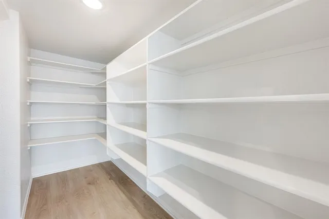 a view of walk in closet with empty racks