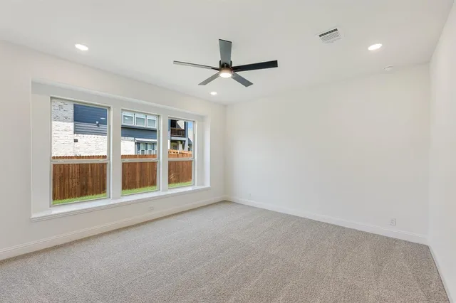 an empty room with a window and ceiling fan