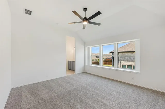 a view of a livingroom with a ceiling fan & windows