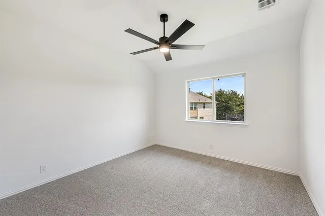 an empty room with a window and a ceiling fan