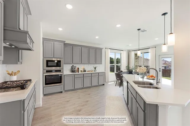 a kitchen with a sink cabinets and wooden floor