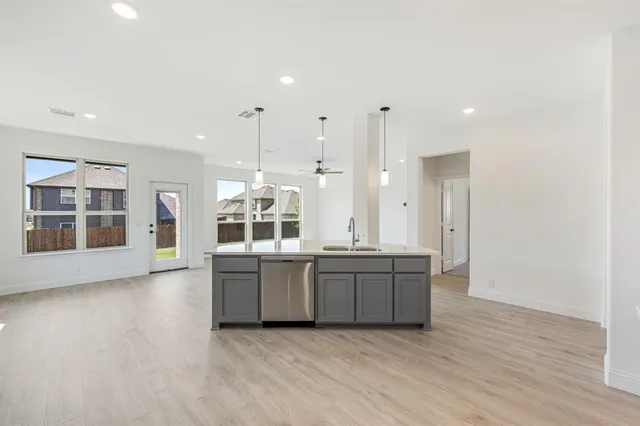 a large kitchen with stainless steel appliances granite countertop a large counter top and a wooden floors