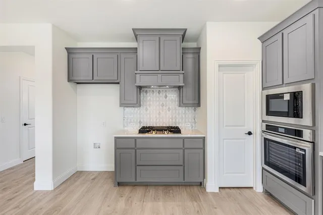 a kitchen with cabinets and steel appliances