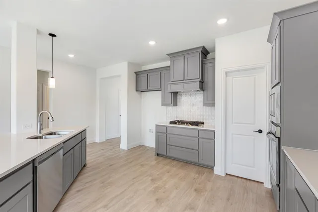a kitchen with kitchen island granite countertop a sink stove and refrigerator