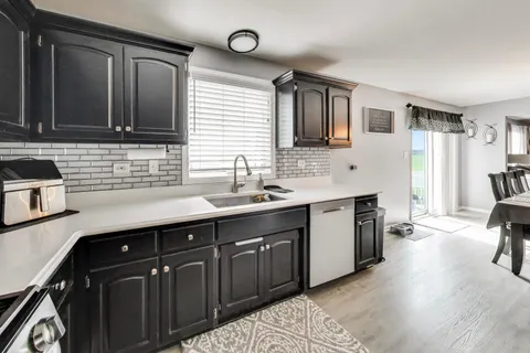 a kitchen with stainless steel appliances granite countertop a refrigerator a stove and a sink