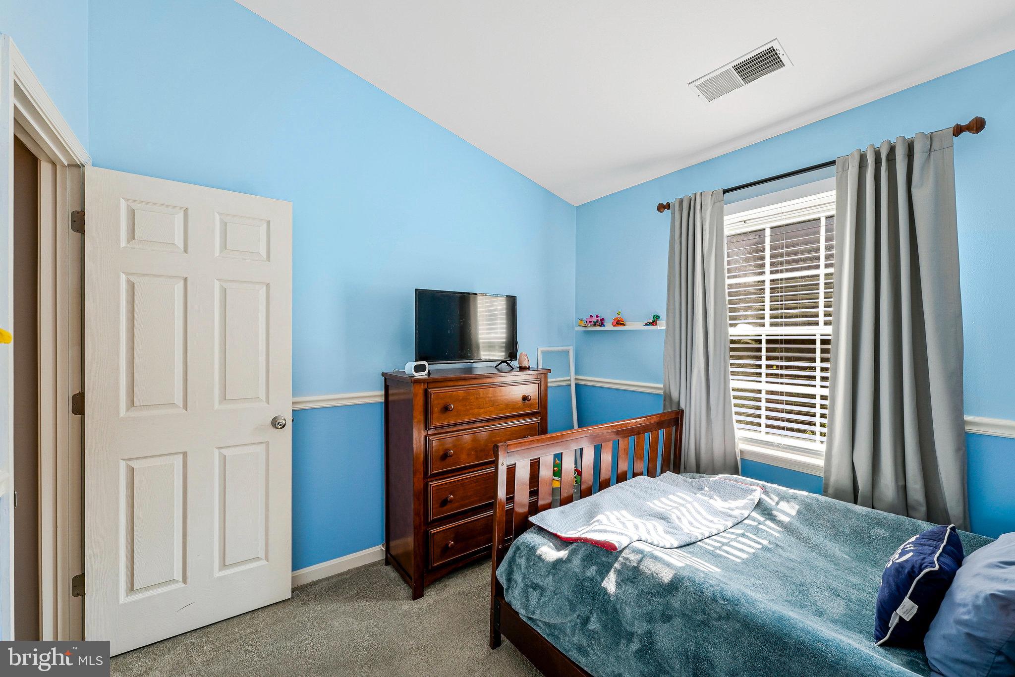 1085 Smartts Lane Northeast Leesburg, VA 20176 - Photo 18 of 38 a bedroom with a bed and a flat screen tv