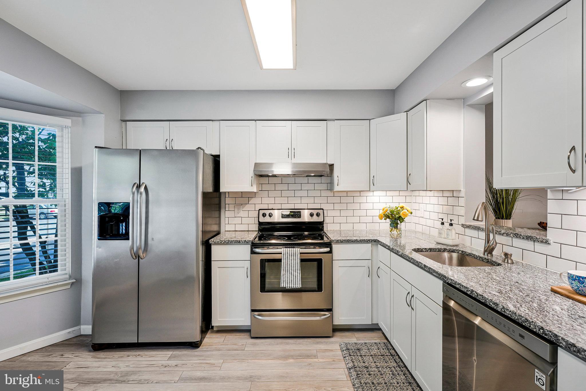 1085 Smartts Lane Northeast Leesburg, VA 20176 - Photo 5 of 38 a kitchen with stainless steel appliances granite countertop a stove a refrigerator and a sink