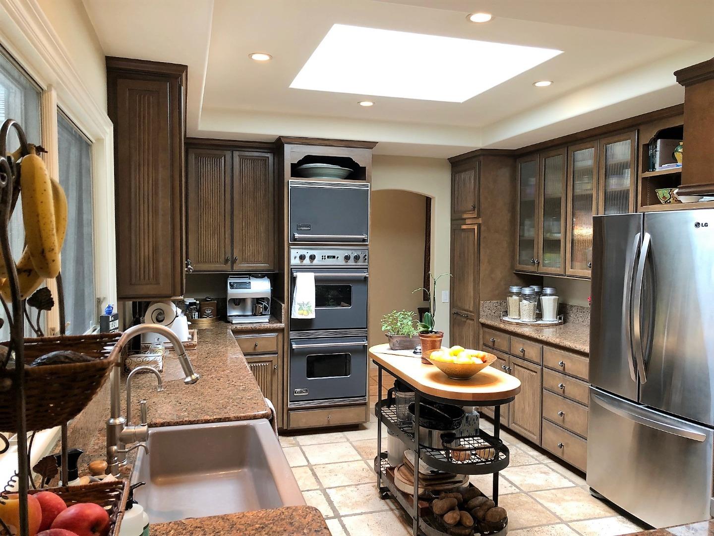1035 Ortega Road Pebble Beach, CA 93953 - Photo 9 of 18 a kitchen with stainless steel appliances kitchen island granite countertop a sink refrigerator and cabinets