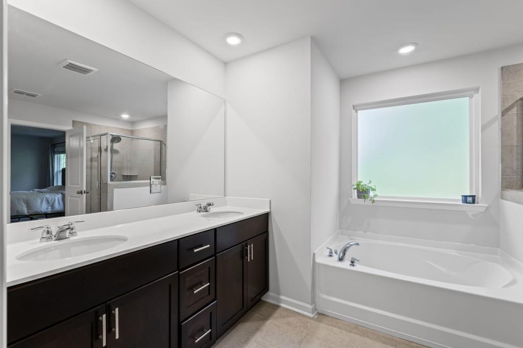 346 Wells Circle Canton, GA 30114 - Photo 24 of 35 a bathroom with a tub double sink and mirror
