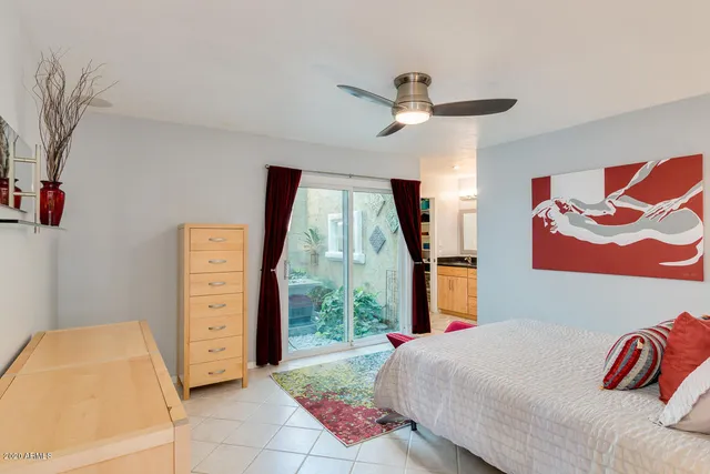 a bedroom with a bed and a painting on the wall