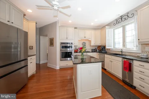 a view of a dining room with furniture a kitchen and chandelier