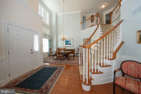 a living room with couches and a dining table with wooden floor