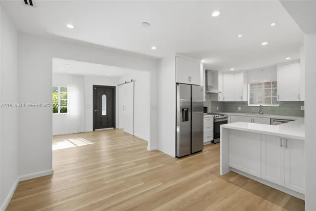 a view of a kitchen with a sink and a refrigerator
