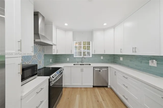 a kitchen with a sink white cabinets and white appliances