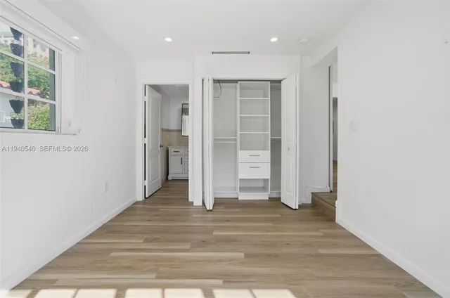 a view of a hallway with wooden floor and entryway