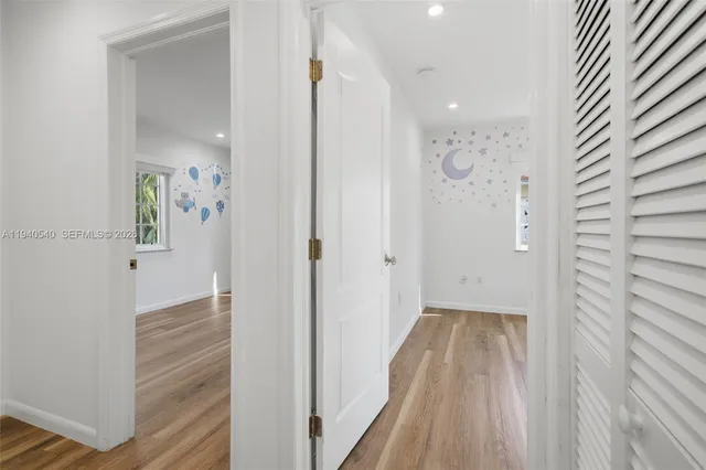a view of a hallway with wooden floor and closet