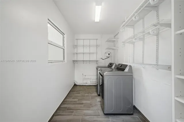 a utility room with cabinets washer and dryer