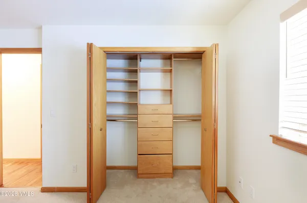 a view of walk in closet with empty racks