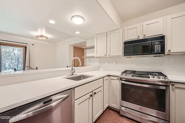 a kitchen with sink a microwave and cabinets