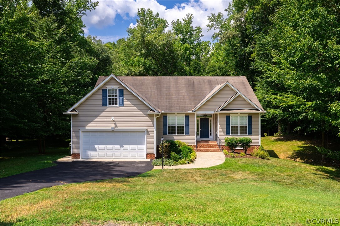 a front view of a house with a yard and trees