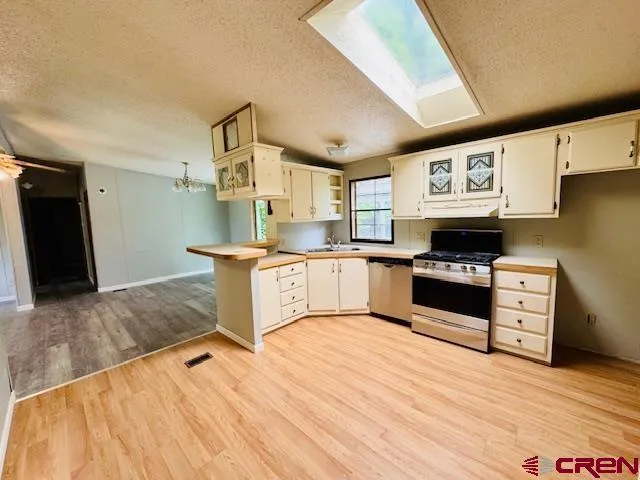 a kitchen with stainless steel appliances kitchen island granite countertop a refrigerator stove and sink