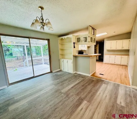 a view of a kitchen with a sink wooden cabinets and a large window