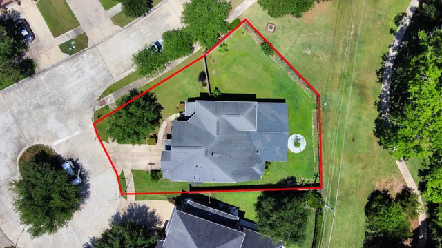 an aerial view of residential houses with outdoor space and trees
