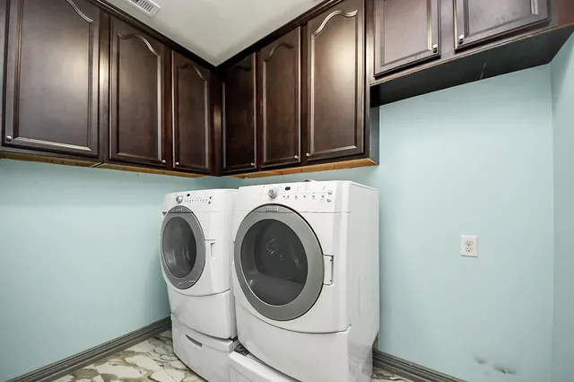 a kitchen with granite countertop a dining table chairs cabinets and stainless steel appliances