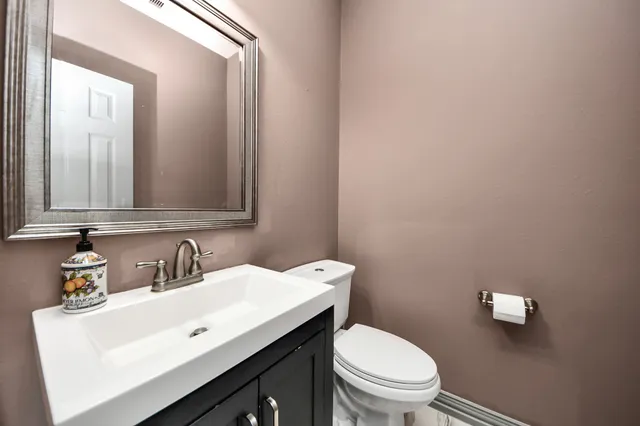 a kitchen with stainless steel appliances granite countertop a stove a refrigerator a sink a dining table and chairs with wooden floor