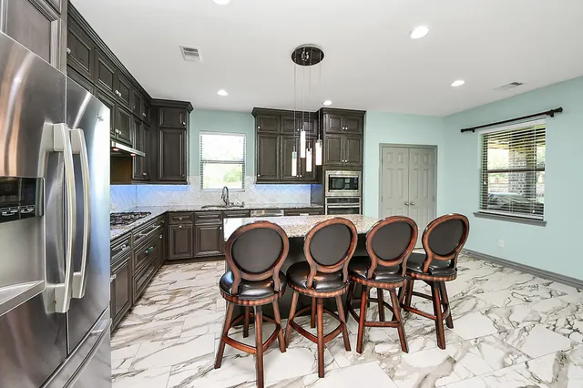 a kitchen with stainless steel appliances kitchen island granite countertop a sink and cabinets