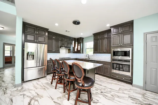 a kitchen with granite countertop a stove and a wooden floors