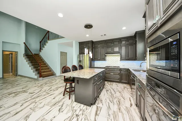 a kitchen with granite countertop a sink a counter top space and living room area