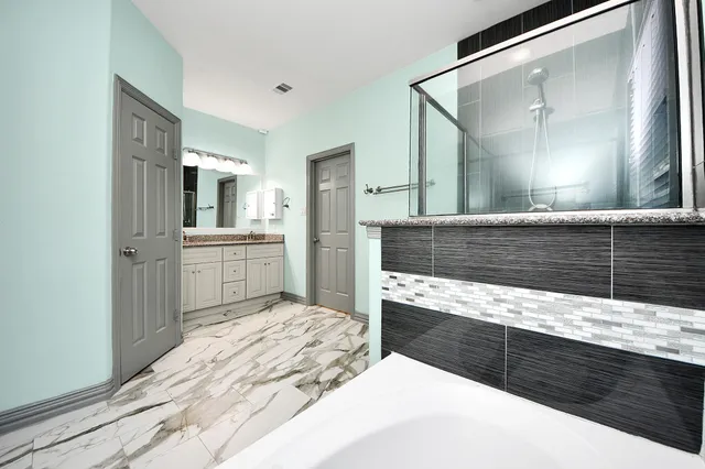 a bathroom with a granite countertop sink a toilet and shower