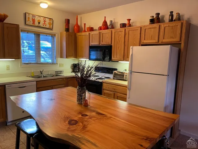 a kitchen with a table chairs refrigerator and cabinets