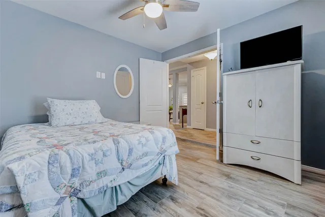 a bedroom with a bed and a flat tv screen on dresser