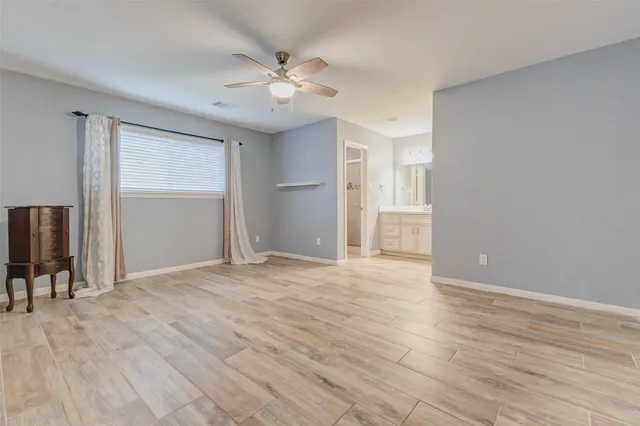 a view of an empty room with wooden floor