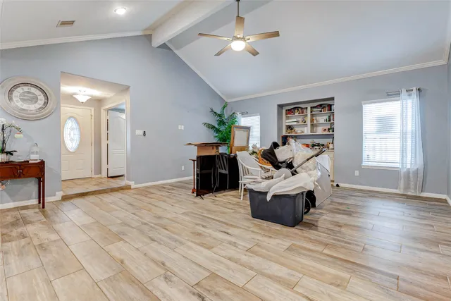 a living room with couches and kitchen view with wooden floor