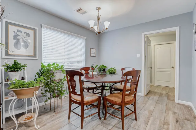 a dining room with furniture potted plants and wooden floor