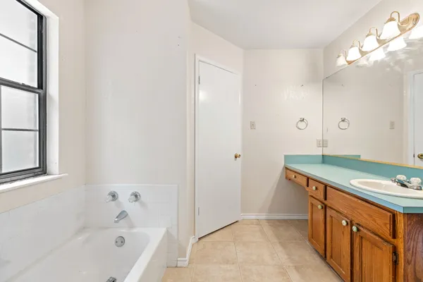 a bathroom with a tub sink and mirror