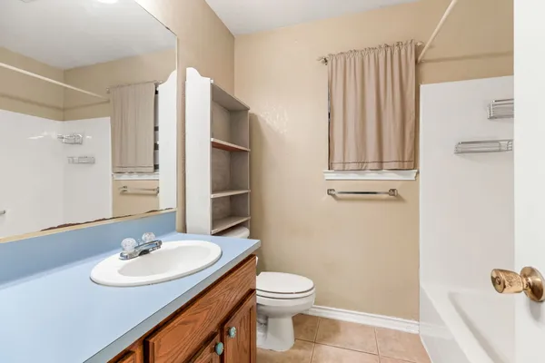 a bathroom with a sink a toilet and a mirror