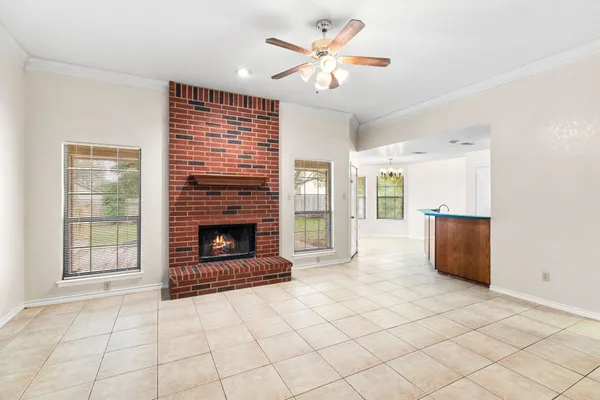 a living room with stainless steel appliances furniture a fireplace and a open kitchen