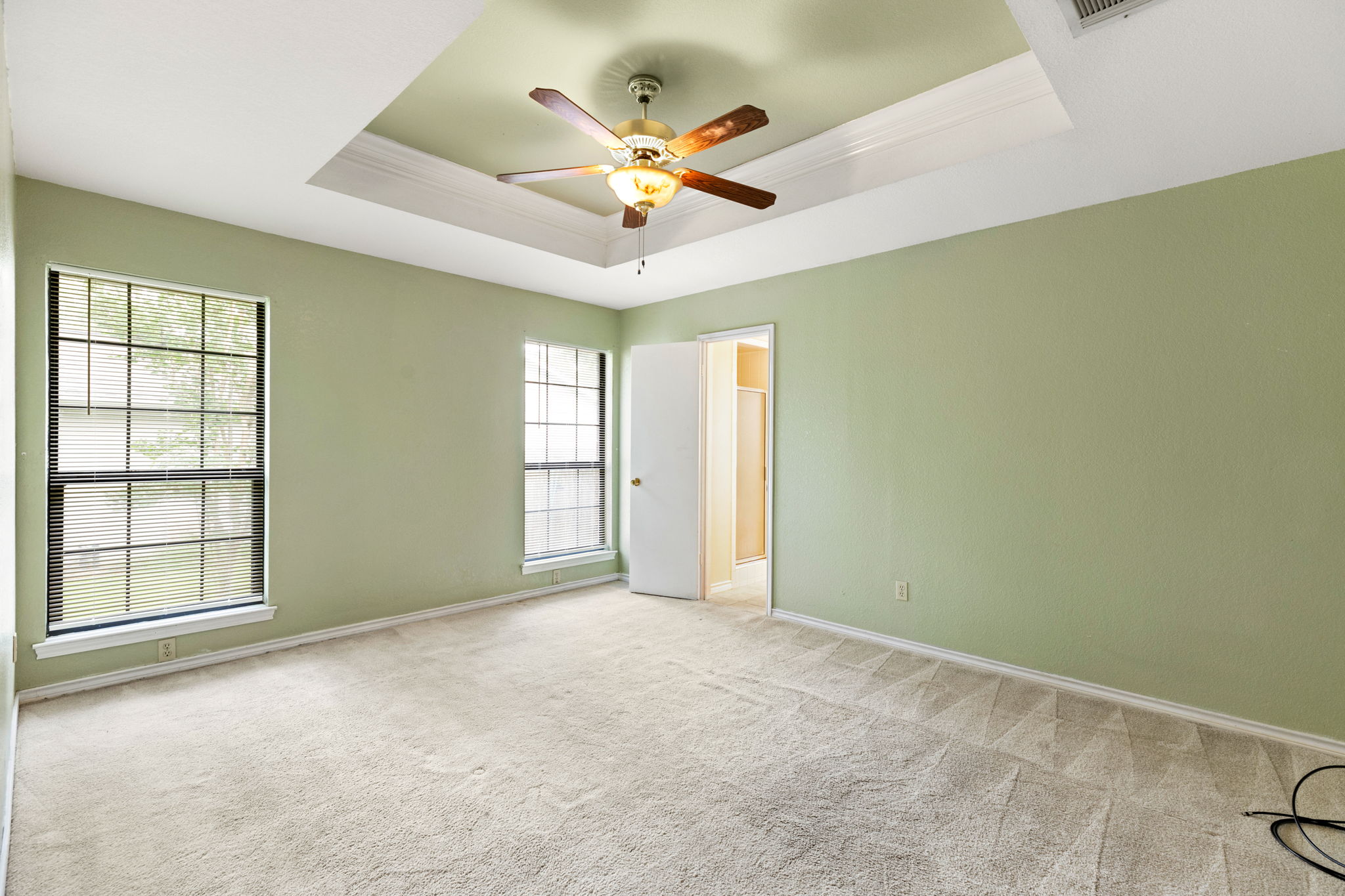 1502 Oak Knoll Lane Lockhart, TX 78644 - Photo 10 of 18 Carpeted bedroom featuring crown molding, a raised ceiling, and ceiling fan