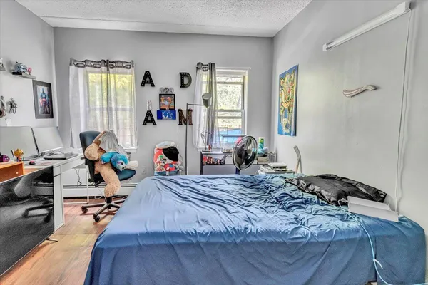 a room with a bed and a wooden floor