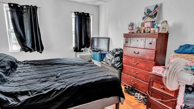 a bedroom with a bed and a flat tv screen on the dresser