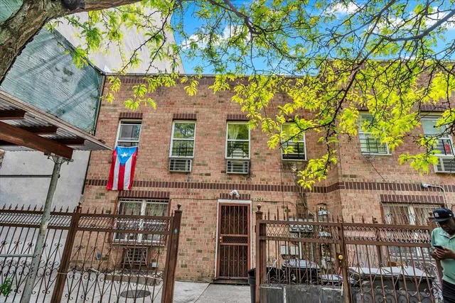 a front view of a building with a tree