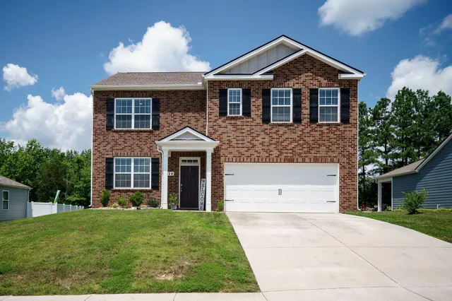 a front view of a house with a yard and garage