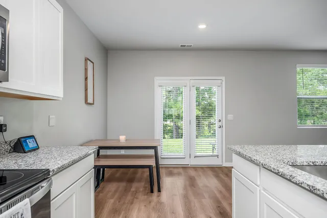 a kitchen with granite countertop a sink a stove and wooden floor