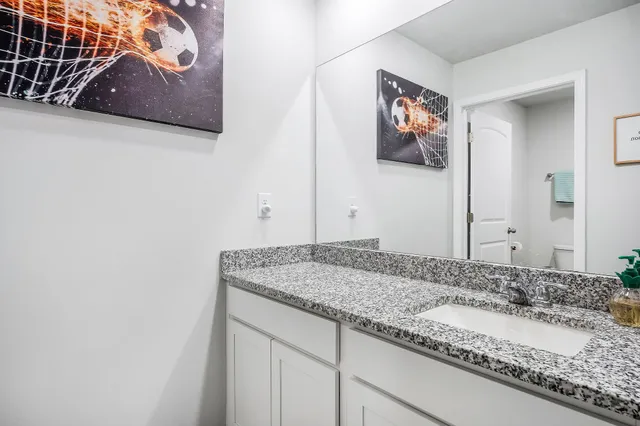 a bathroom with a granite countertop sink and a mirror