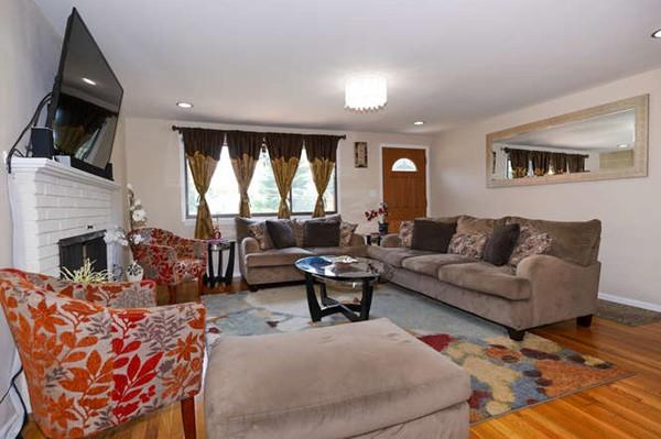 19 McAdams Road Framingham, MA 01701 - Photo 6 of 27 a living room with furniture a fireplace and a flat screen tv